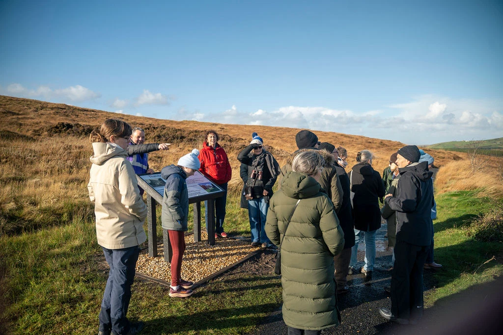 Group exploring Mayo Dark Sky Park during a sunny walking tour, with an informative guide in an open landscape setting.