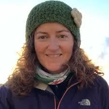 Woman in warm clothing smiling outdoors at Mayo Dark Sky Festival.