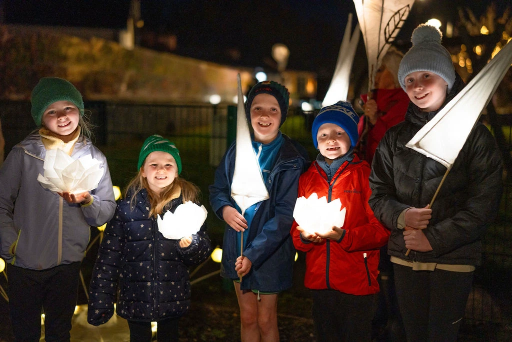 Children holding lanterns at night during the Mayo Dark Sky Festival outdoor event.