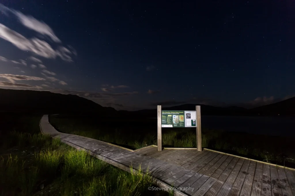 Starlit path and information board at Mayo Dark Sky Festival, showcasing a serene night sky experience.